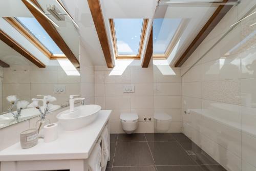 W łazience znajduje się toaleta z umywalką i świetlik. w obiekcie Zen Luxury Apartments w mieście Zadar