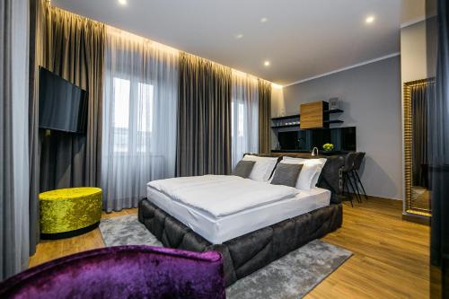 a bedroom with a king sized bed and a couch at Teatro Suite & Rooms in Rijeka