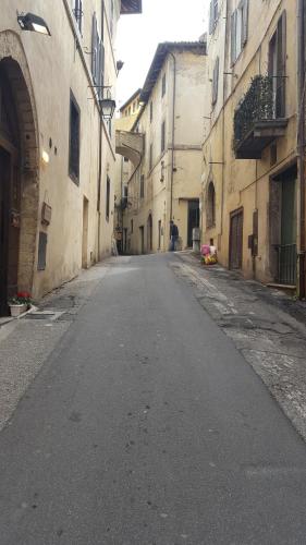 an empty street in an alley between two buildings at Via della Posterna in Spoleto