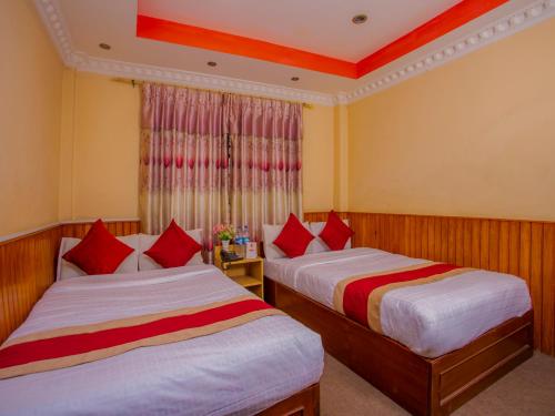 a hotel room with two beds and two nightstands at OYO 305 Hotel Gauri in Pashupatināth