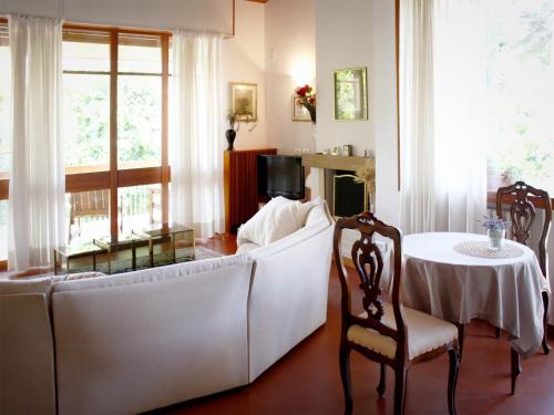 Bed And Breakfast 22 Garibaldi Home في ريتشيوني: غرفة معيشة مع أريكة بيضاء وطاولة