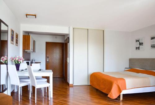 a bedroom with a bed and a table and chairs at Przystań przy plaży in Władysławowo