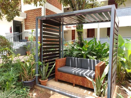 a bench in a pergola in a garden at Fairway Boutique Hotel - Kampala, Uganda in Kampala