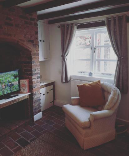 a living room with a chair and a fireplace at Gorgeview Cottage in Ironbridge