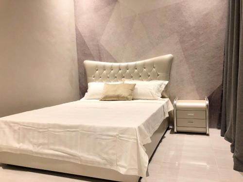 a bedroom with a white bed with a large headboard at Langkawi M seaview Apartment in Kuah