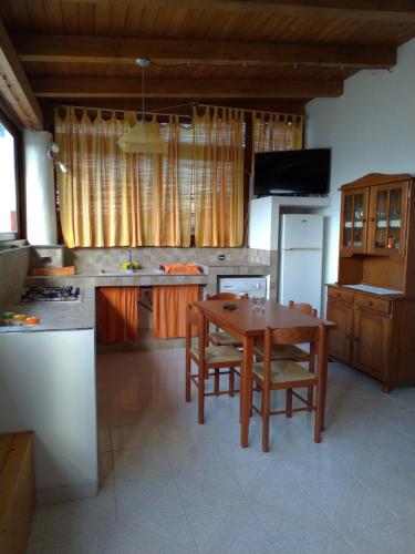 eine Küche mit einem Holztisch und einem Esszimmer in der Unterkunft L' appartamentino in Leni