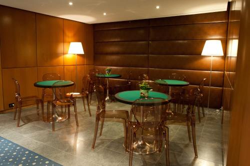 a dining room with green tables and chairs at Hotel Rivè - Complesso Turistico Campo Smith in Bardonecchia