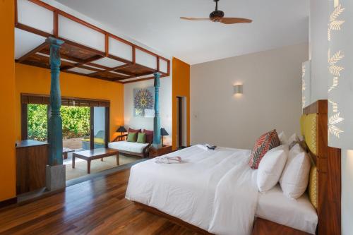 a bedroom with a bed and a living room at Wattura Resort & Spa in Negombo