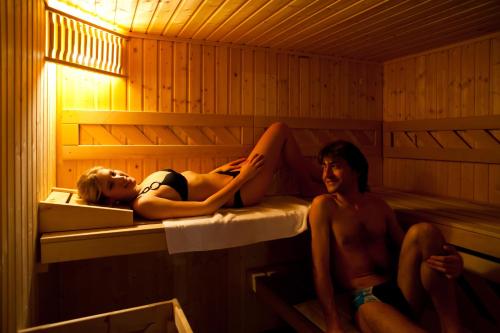 a couple of people laying in a sauna at Hotel Rivè - Complesso Turistico Campo Smith in Bardonecchia