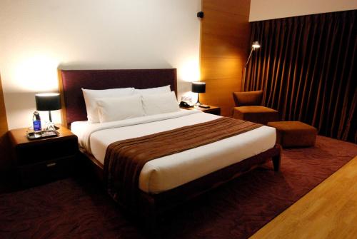 a hotel room with a large bed and a chair at Hotel Parc Estique in Pune
