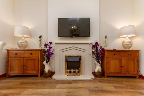 a living room with a fireplace with a tv above it at Beachcliffe Lodge Apartments in Blackpool