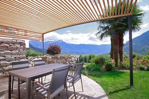 a wooden table and chairs on a patio with a view at Plarserhof in Lagundo