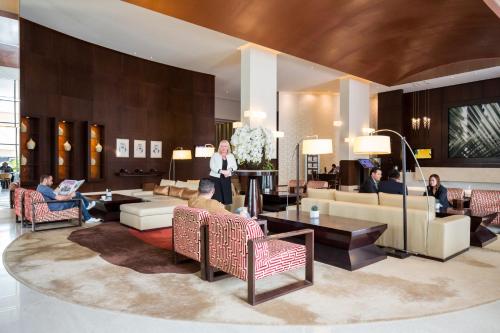 a woman standing in a lobby with a group of people at Novotel Deira Creekside Dubai in Dubai