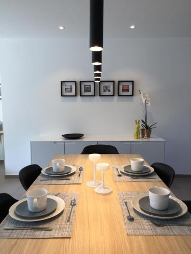- une table à manger avec des assiettes et des tasses dans l'établissement Vakantiewoning De Konijnenweg, à La Panne