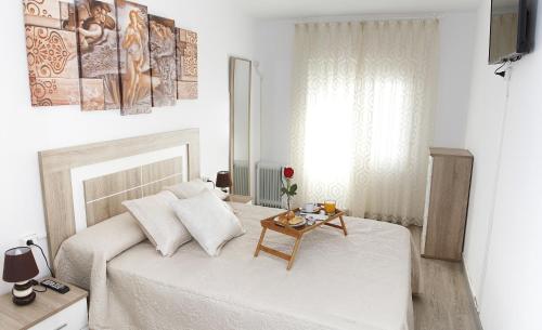 ヒホンにあるLa CaSa De Suの白いベッドルーム(ベッド1台、テーブル付)