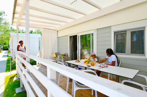 twee vrouwen aan een tafel op een patio bij Isamar Holiday Village in Ca Lino