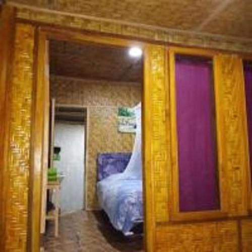 a doorway to a bedroom with a bed in it at Tereng Wilis bungalows in Tetebatu