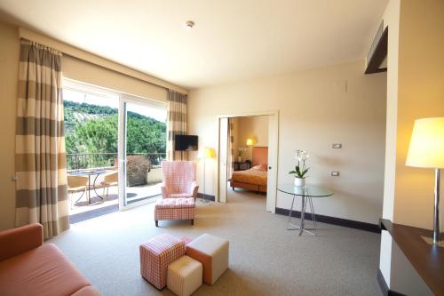 a living room with a couch and a bed and a balcony at Villa Maria Hotel & SPA in Francavilla al Mare