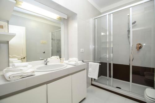 bagno bianco con doccia e lavandino di Royal by PortofinoHomes a Portofino