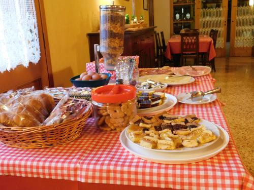 a table with plates of food on a red and white table cloth at Agriturismo Al Casale in Codroipo