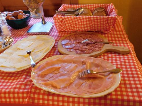 a table with plates of food on a red checked table cloth at Agriturismo Al Casale in Codroipo