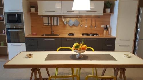 - une cuisine avec une table et un bol de fruits dans l'établissement Anteo holiday house, à Riposto
