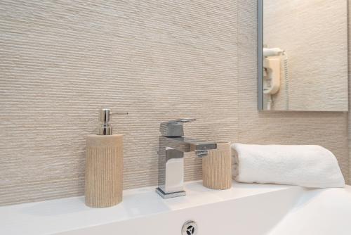 a bathroom sink with two soap dispensers on it at Villa Divino Afflante in Pirovac