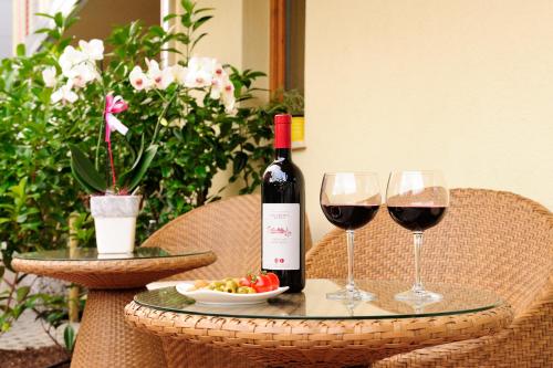 a table with two glasses of wine and a plate of grapes at Eco Hotel Bonapace in Nago-Torbole