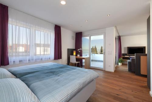 a large bedroom with a large bed and a desk at Haus Bank-Specker in exclusiver Seelage in Immenstaad am Bodensee