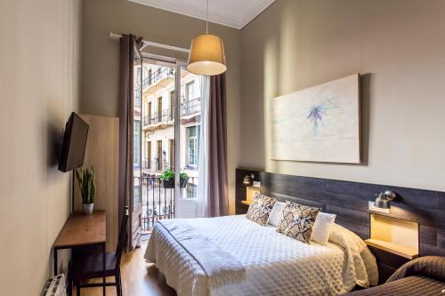 a bedroom with a bed and a window at El Born Guest House by Casa Consell in Barcelona