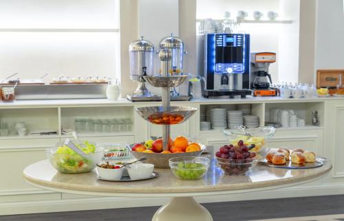 a table with bowls of fruit on it in a kitchen at Promenáda Romantic Hotel in Karlovy Vary