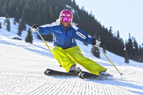 a woman is skiing down a snow covered slope at T3 Hotel Mira Val in Flims