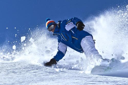 a man is skiing down a snow covered slope at T3 Hotel Mira Val in Flims