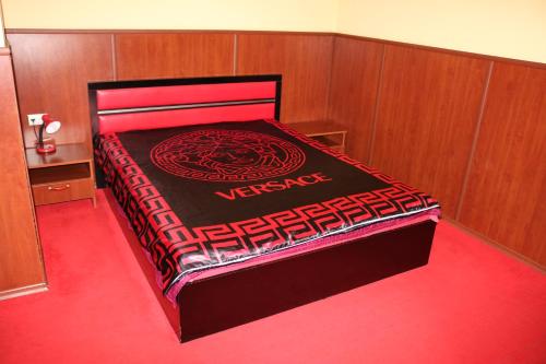 a large bed in a room with a red carpet at семеен хотел Визаж in Yambol