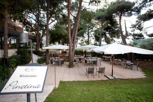 an outdoor patio with tables and chairs and umbrellas at Villa Maria Hotel & SPA in Francavilla al Mare