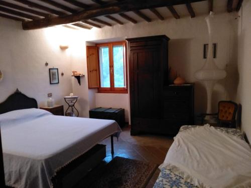 ein Schlafzimmer mit einem Bett, einer Kommode und einem Fenster in der Unterkunft Rustico in Bagnoregio