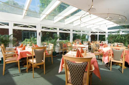 uma sala de jantar com mesas, cadeiras e janelas em HOTEL PÜNJER em Witzhave