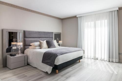 a bedroom with a large bed and a large window at Boutique Hotel B51 in Marbella