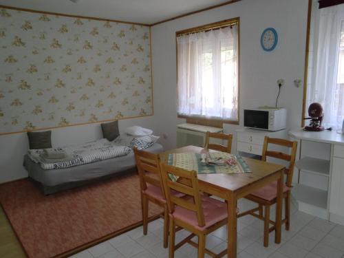 a living room with a table and chairs and a couch at Elizabet in Hévíz