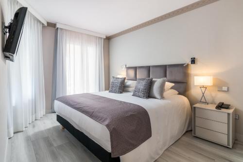 a bedroom with a large bed and a television at Boutique Hotel B51 in Marbella