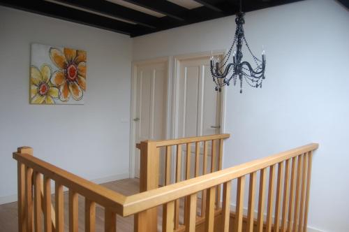 a wooden staircase with a chandelier in a room at Toenders in Wintelre