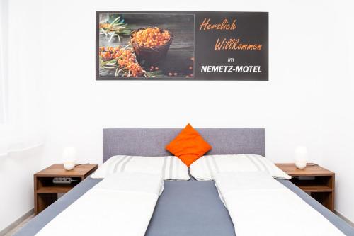 a bed in a room with a poster on the wall at Nemetz-Motel in Böheimkirchen