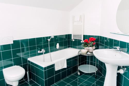 zieloną łazienkę z wanną i umywalką w obiekcie Hostellerie Du Golf w mieście Pecetto