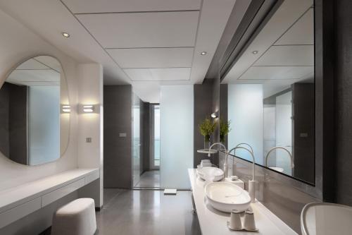 a bathroom with two sinks and a large mirror at The Mangrovetree Sanya Resort in Sanya