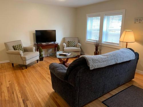 sala de estar con sofá, 2 sillas y TV en The Countrypolitan, en Lewisburg