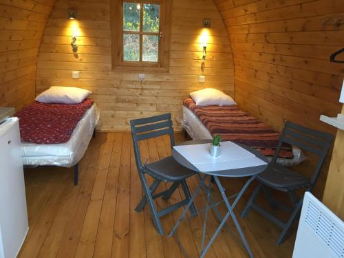 une chambre avec deux lits, une table et des chaises dans l'établissement West Camping, à Perros-Guirec