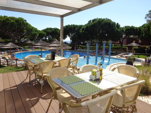 a patio with tables and chairs next to a swimming pool at Bicos 101 - Shared Pool - 4 Guests - Albufeira in Albufeira