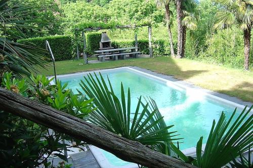 einen Pool mit einer Bank und einem Picknicktisch in der Unterkunft Brissago: Casa Collinetta H in Brissago