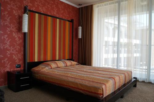 a bedroom with a bed and a large window at Regina Maria Spa Design Hotel in Balchik