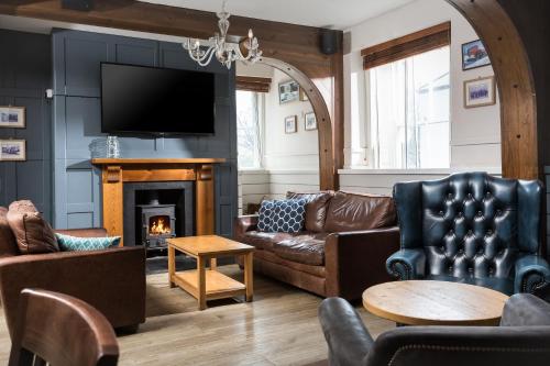 a living room with a couch and a fireplace at Rashleigh Arms in St Austell